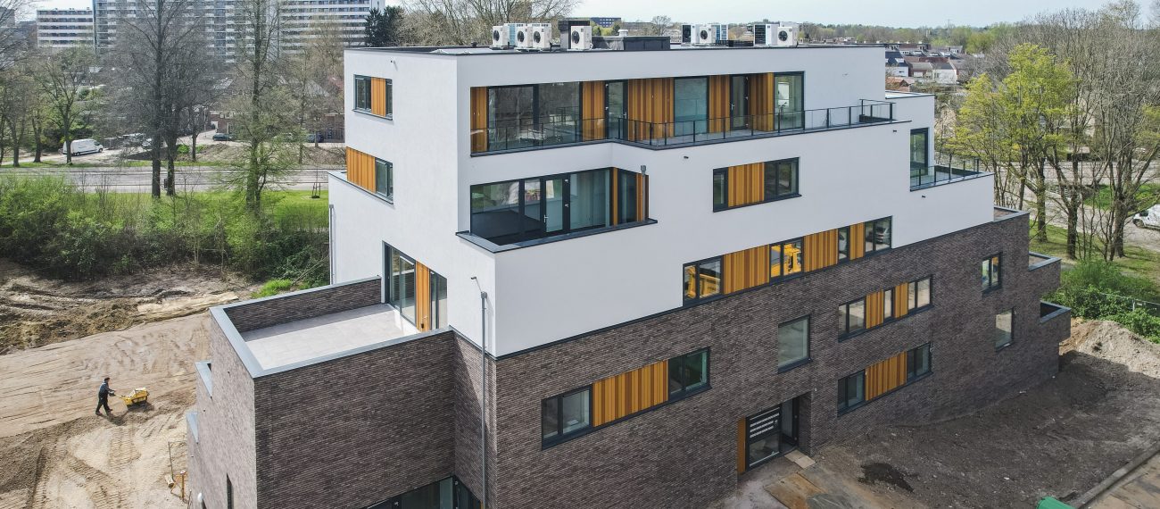 Modern woongebouw met dakterrassen, verticale houten accenten en glas aan bosrand — Gebiedsontwikkeling Parkheuvel Heerlen