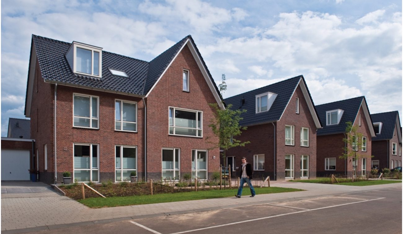 Gezinswoningen met donkere pannendaken en voortuinen aan rustige nieuwbouwstraat