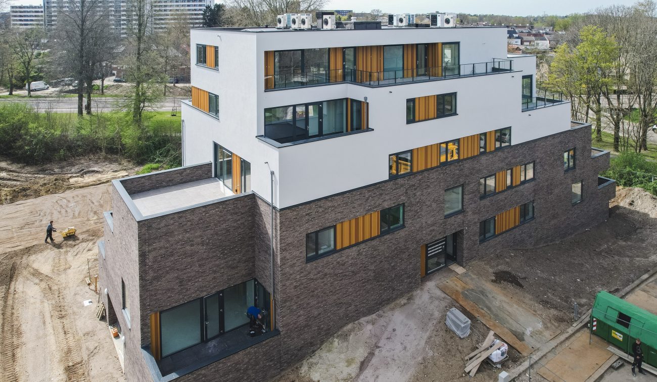 Modern woongebouw met dakterrassen, verticale houten accenten en glas aan bosrand — Gebiedsontwikkeling Parkheuvel Heerlen