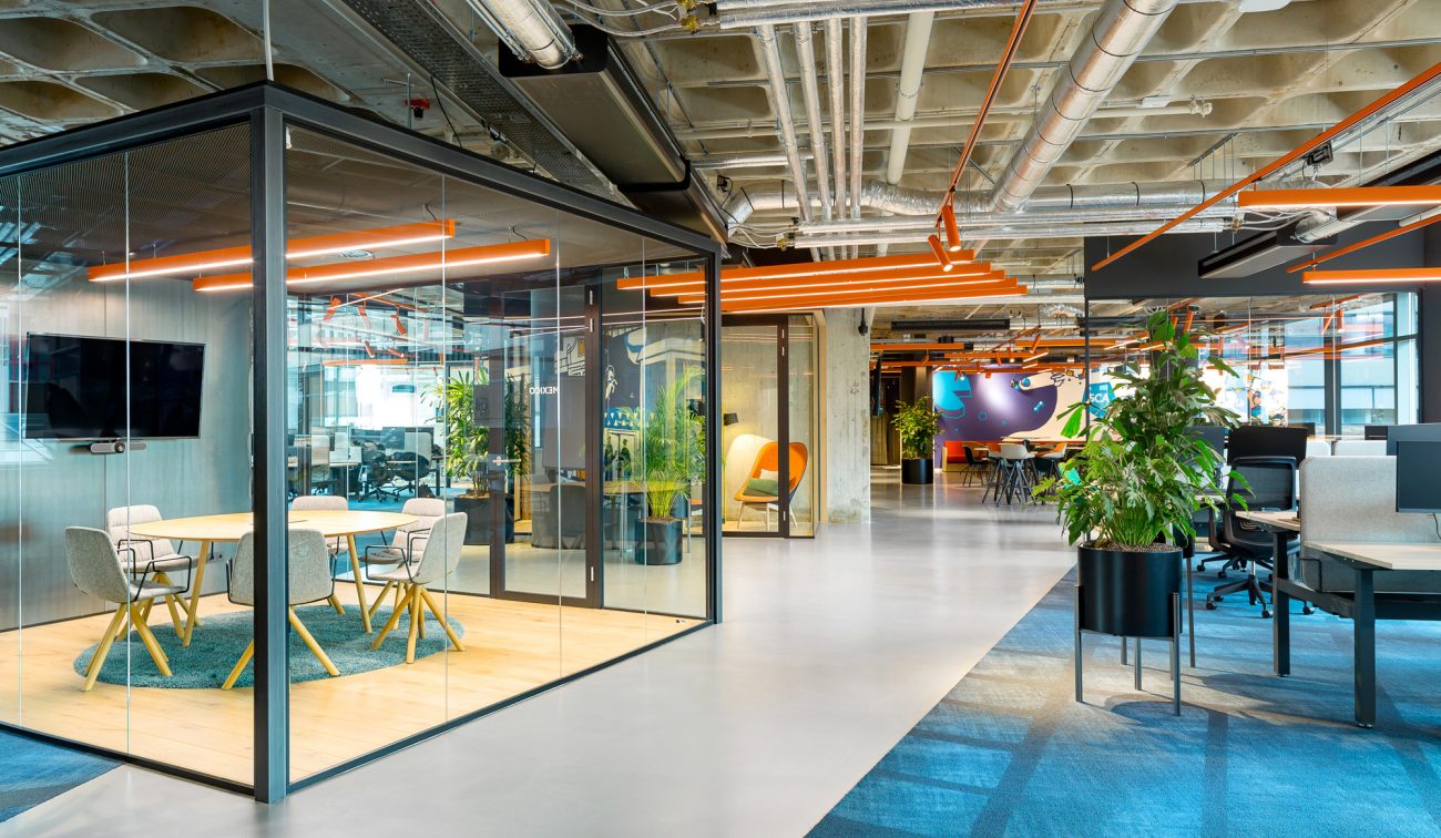 Kantoor 5CA Utrecht: glazen vergaderruimtes, open plafond met oranje lichtlijnen en veel groen