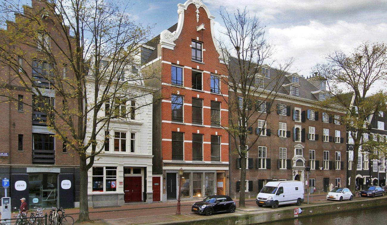 Oudezijds Voorburgwal Amsterdam: herontwikkeld monument met baksteen, ornamenten en gevelpuien