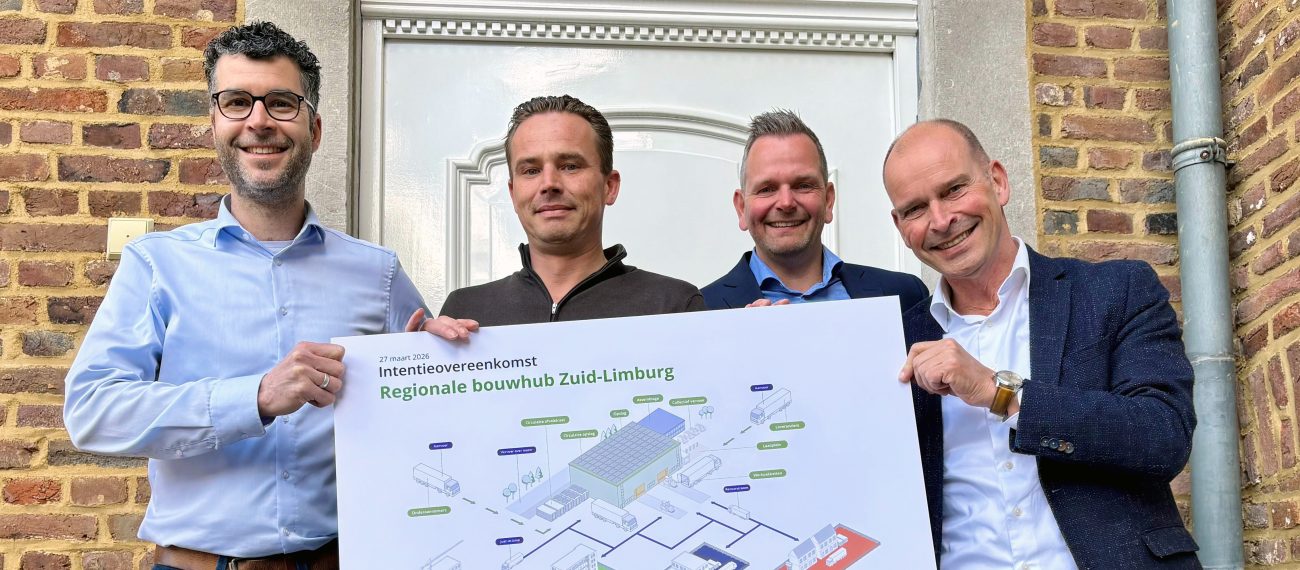 Vier mannen houden een bord omhoog en lachen naar de camera