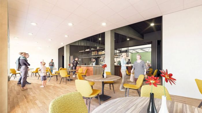 Interieurimpressie van multifunctioneel centrum met bar, zitplekken en bezoekers in open ruimte.