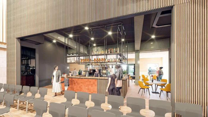 Impressie van horecabar met zitgedeelte en bezoekers in multifunctioneel centrum met houten afwerking.