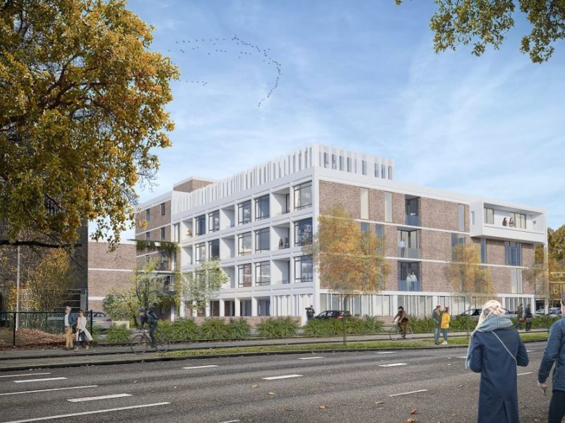 Appartementengebouw met balkons en open galerijen langs straat met bomen en voetgangers