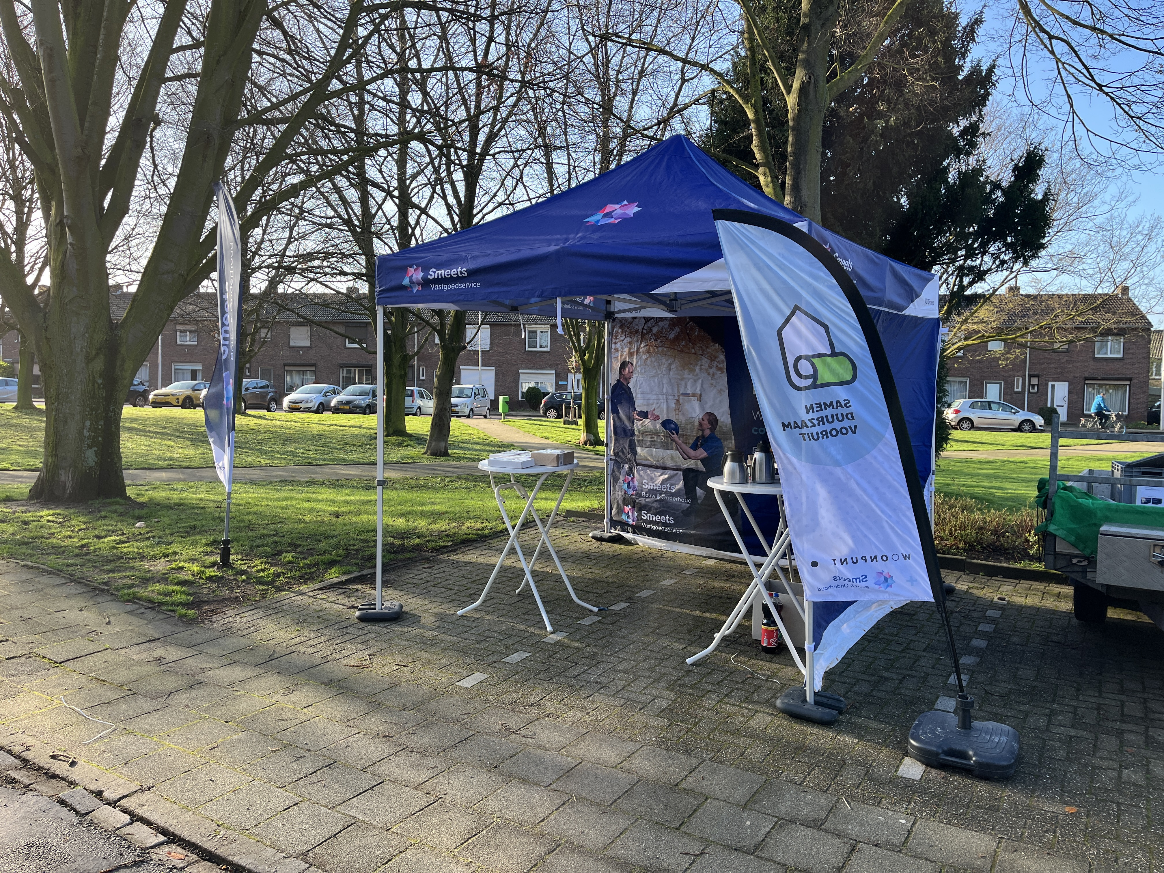 Een opgezette tent met statafels waar koffie en thee opstaan