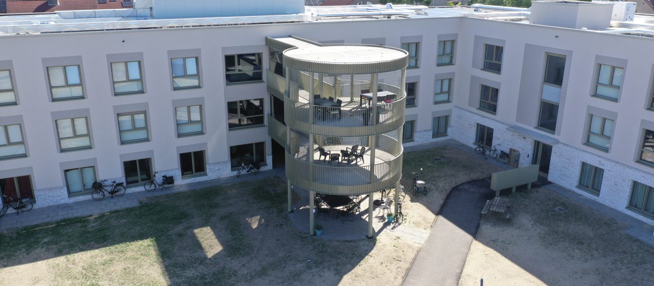 Ronde balkontoren bij zorgwoningen Risselthof Horst, binnenhof met pad en gras