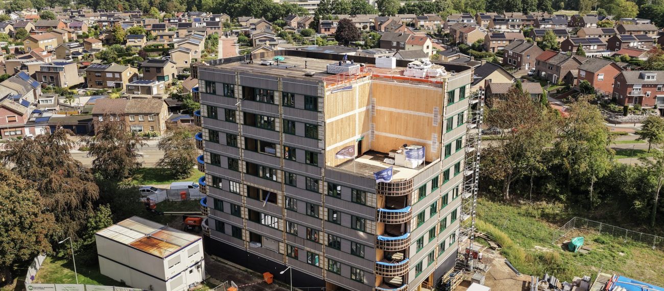 Appartementengebouw in aanbouw met omliggende woonwijk vanuit vogelperspectief