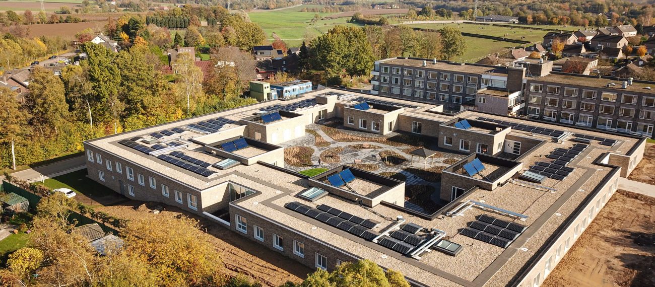 Luchtfoto verpleeghuis Panhuys Hulsberg met zonnepanelen en centrale binnentuin.
