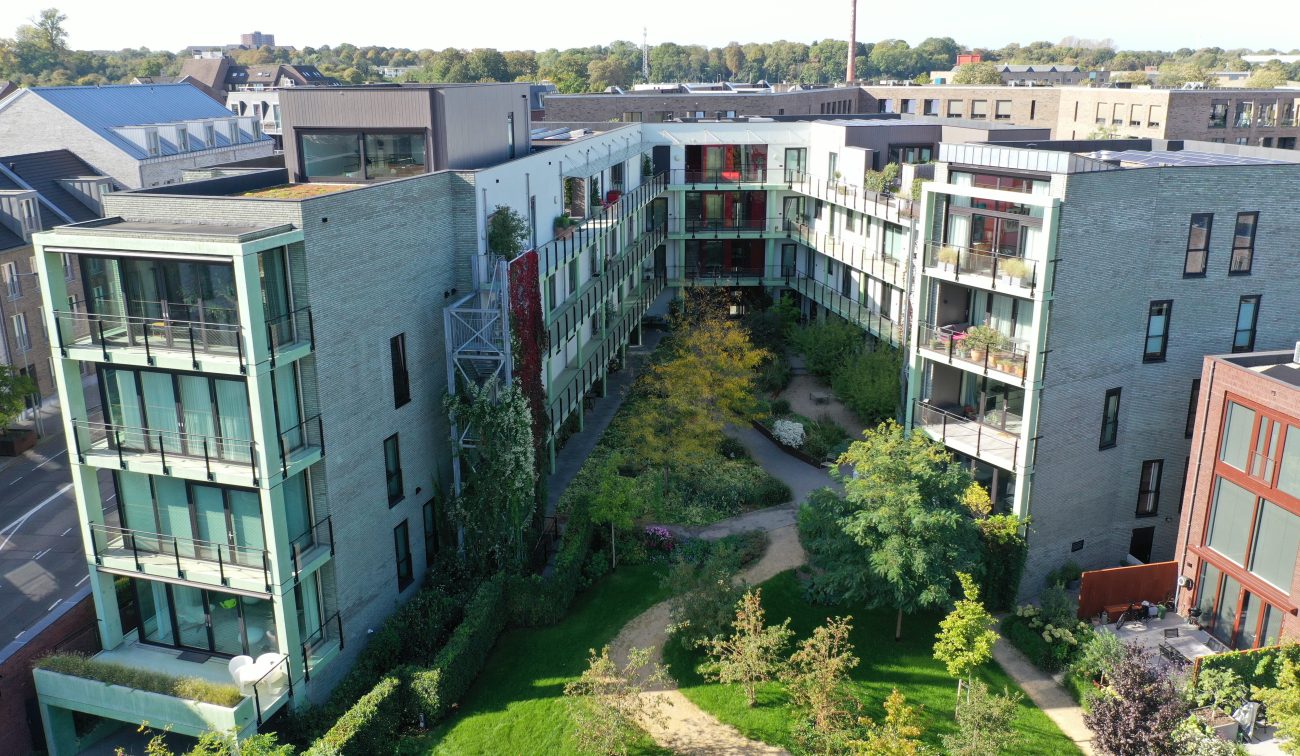 CPO Sphinx Maastricht – U-vormig appartementenblok met groene balkons rond binnentuin met slingerpaden, bomen en klimplanten