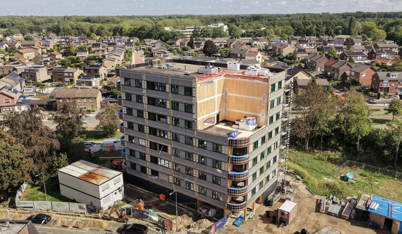 Appartementengebouw in aanbouw met omliggende woonwijk vanuit vogelperspectief
