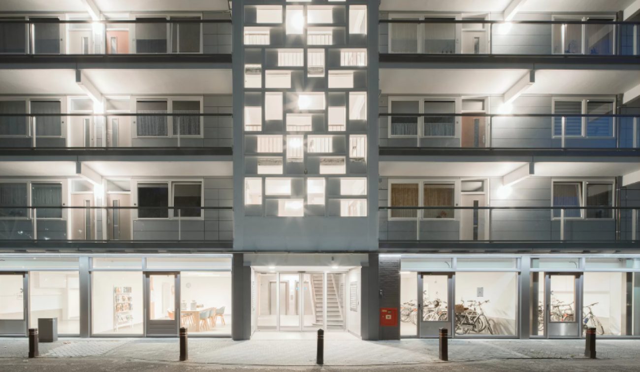 Renovatie Heerlerbaan: verlicht trappenhuis en glazen plint met fietsenstalling.