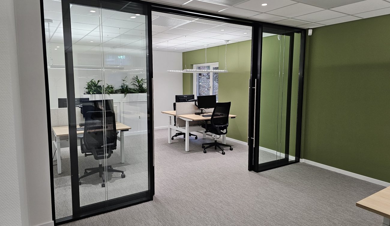 Een kantoorruimte vanaf buiten met bureaus en computers