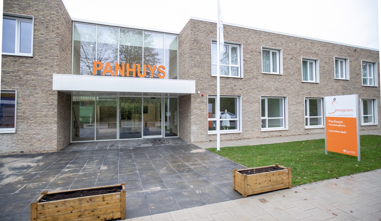 Entree verpleeghuis Panhuys Hulsberg met glazen pui en oranje gevelletters.