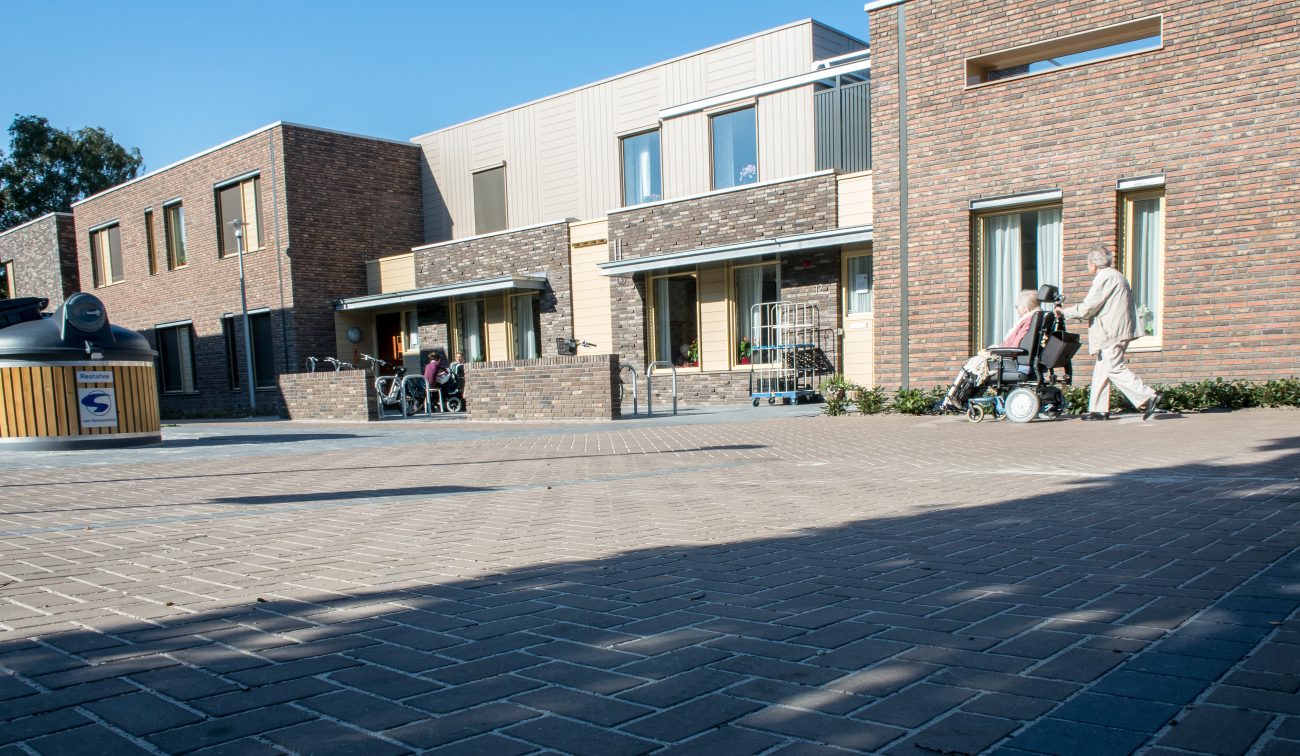 Zorgcomplex Vincentiushof Venray, entreezone met zitje en passerende bezoekers met rolstoel.