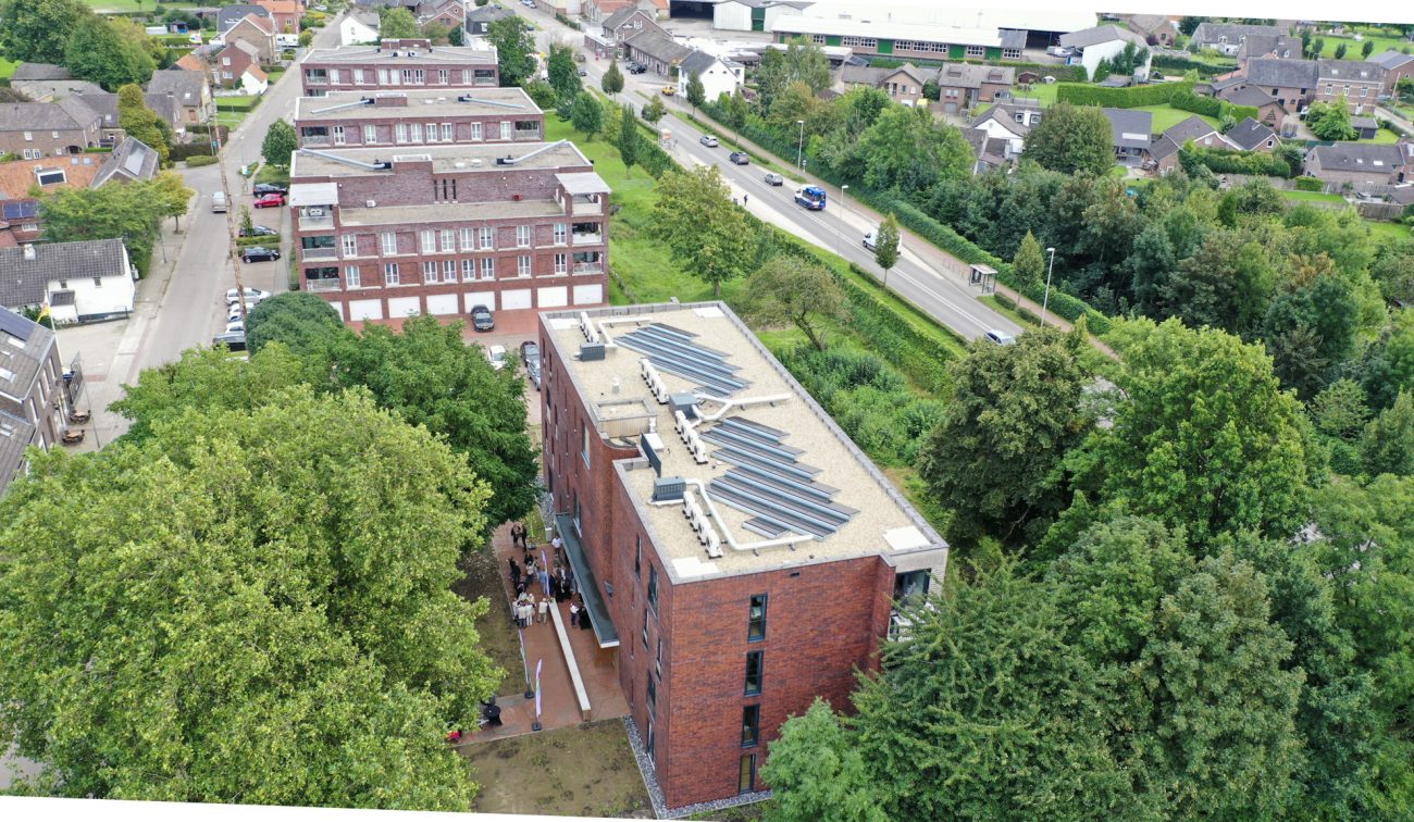 Vogelvlucht sociale huur Margraten met plat dak, technische opstellingen en omliggende wijk.
