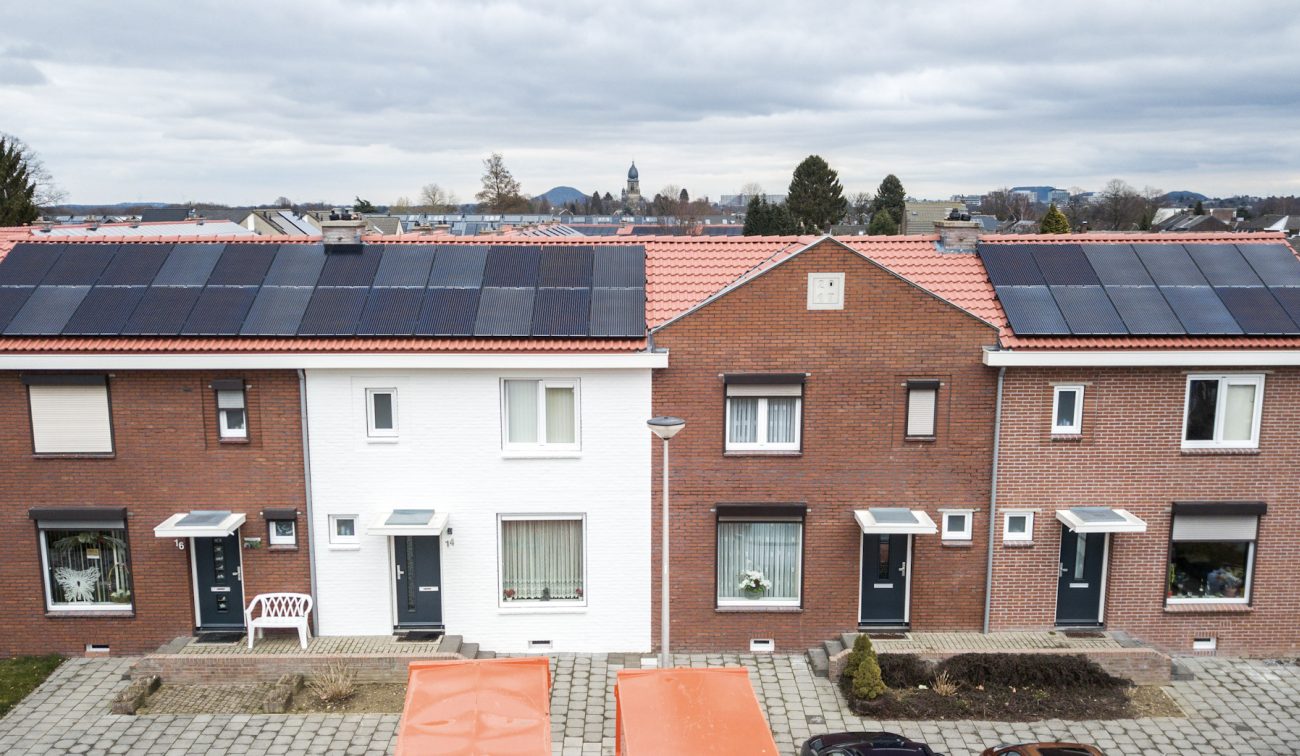 Gerenoveerde rijwoningen Heilust Kerkrade met rode daken en zonnepanelen, frontaal aanzicht.