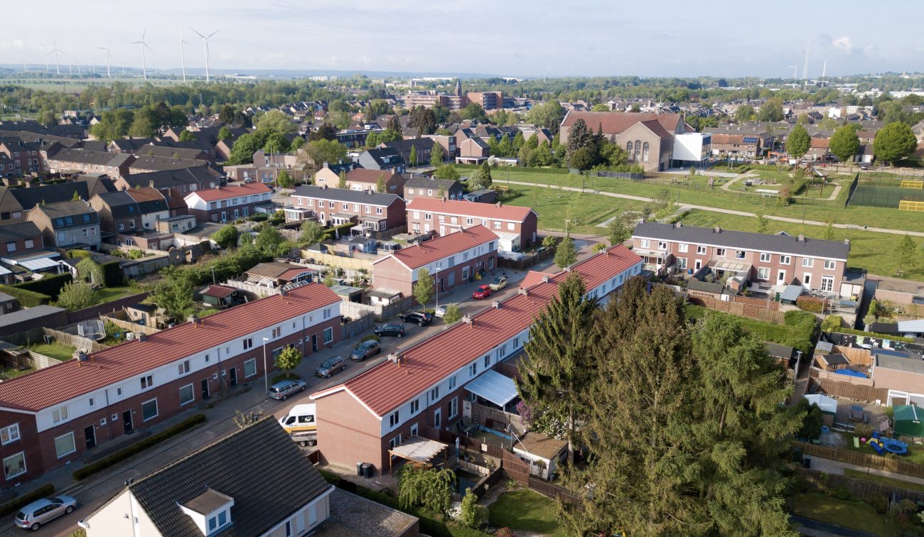 Luchtfoto Heilust Kerkrade: gerenoveerde rijwoningen met nieuwe rode pannendaken.
