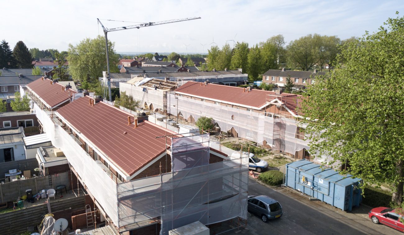 Bouwfase 332 woningen Kerkrade, daken vernieuwd en gevels ingepakt met steigernet.