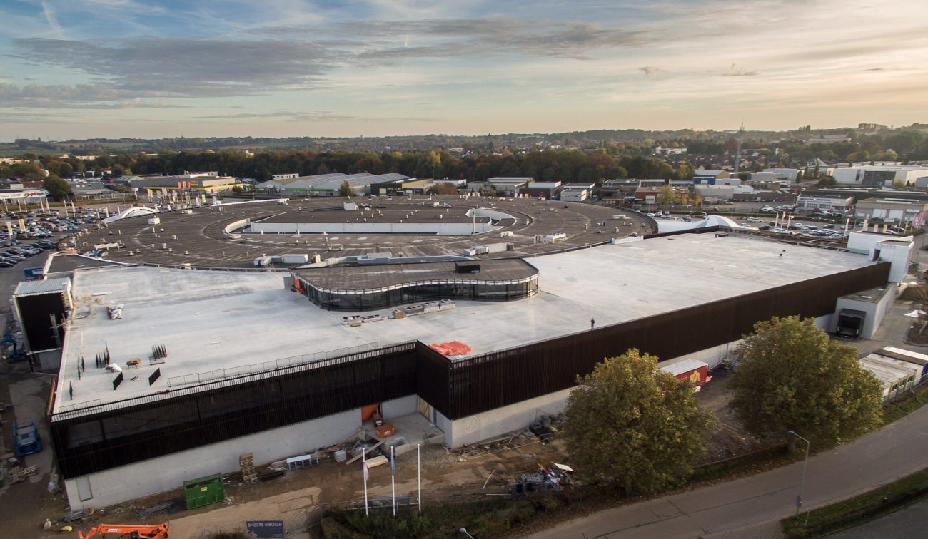 Winkelcentrum Makado Beek na uitbreiding, groot dakvlak en donkere gevelopbouw.