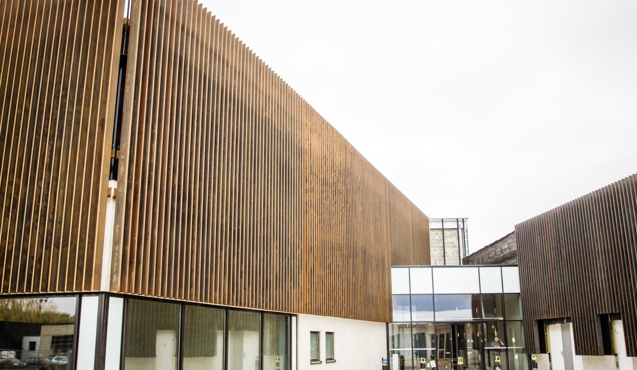 Architectonisch pand met verticale houten bekleding en transparante lobby.