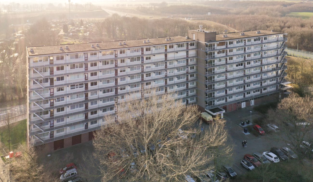 “Luchtfoto lange galerijflat met doorlopende balkons en parkeerterrein — Groot onderhoud Albert Schweitzer Brunssum