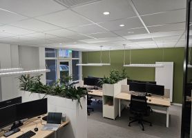 Een moderne kantoorruimte waarin verschillende bureaus staan met computers