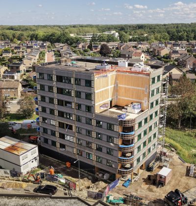 Appartementengebouw in aanbouw met omliggende woonwijk vanuit vogelperspectief