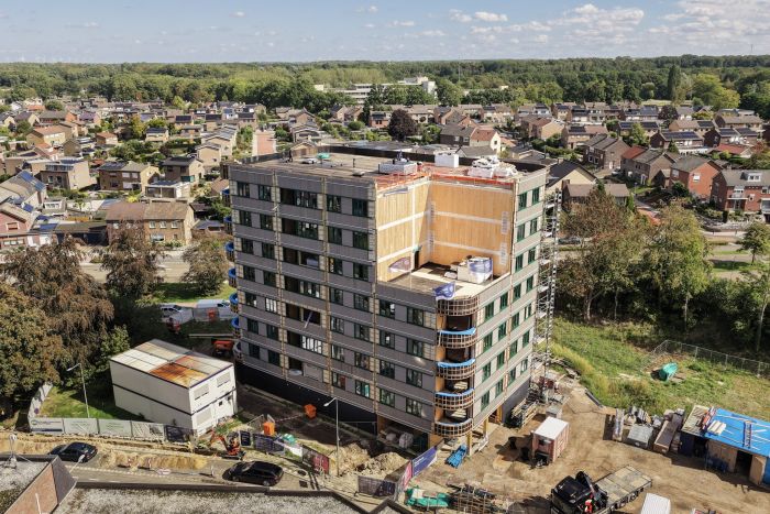 Appartementengebouw in aanbouw met omliggende woonwijk vanuit vogelperspectief