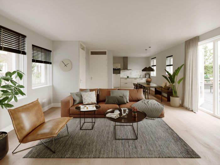 Nieuwbouw Nieuw Absbroek Geleen – moderne woonkamer met bruine leren bank, open keuken, eethoek, veel licht en schuifdeur naar tuin