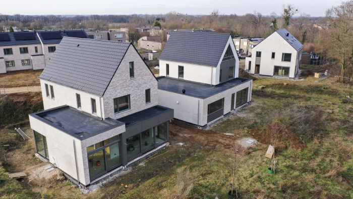 CPO Meerdel Elsloo – vrijstaande nieuwbouwwoningen met grijs metselwerk, zadeldaken en platte aanbouwen met grote glaspuien, erf in aanleg