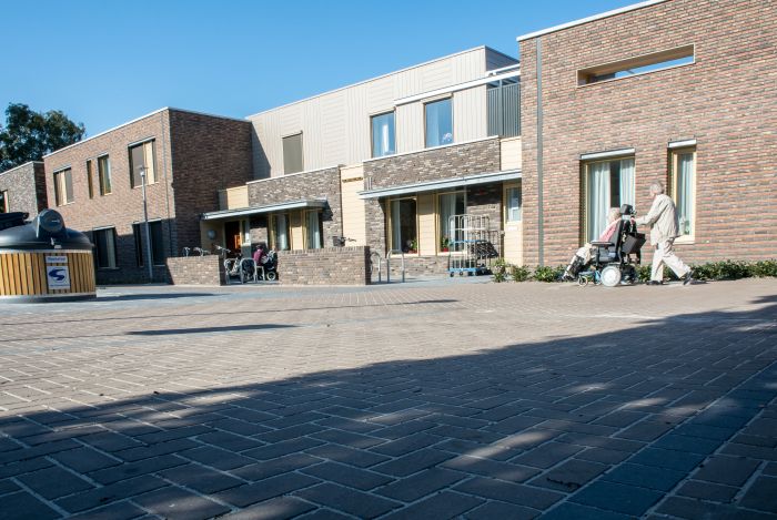 Zorgcomplex Vincentiushof Venray, entreezone met zitje en passerende bezoekers met rolstoel.