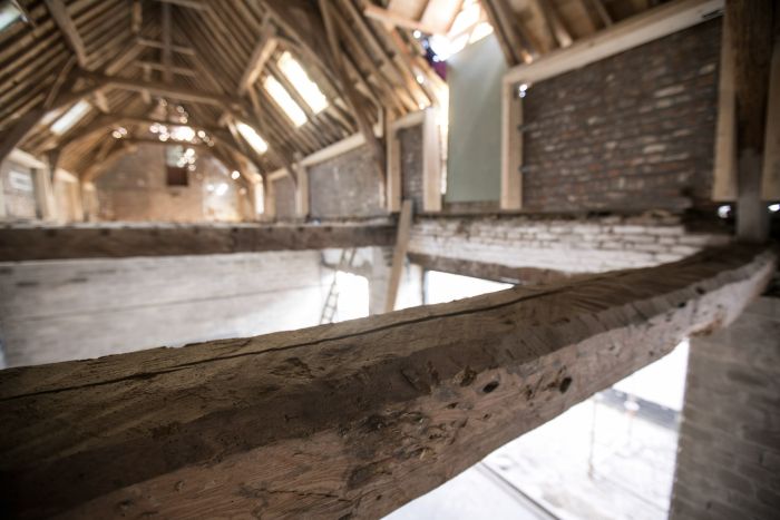 Detail robuuste eiken balk in open kapconstructie tijdens restauratie — Herbestemming hoeve tot appartementen Maastricht