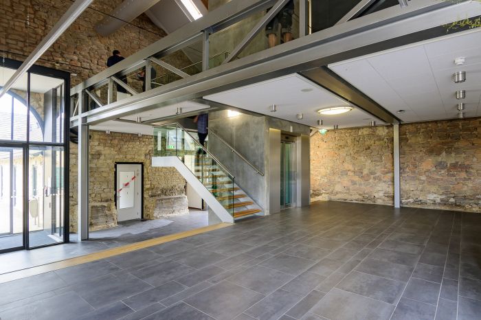 Entreehal Hoeve Overhuizen met stalen mezzanine, glazen trap en lift in natuursteen