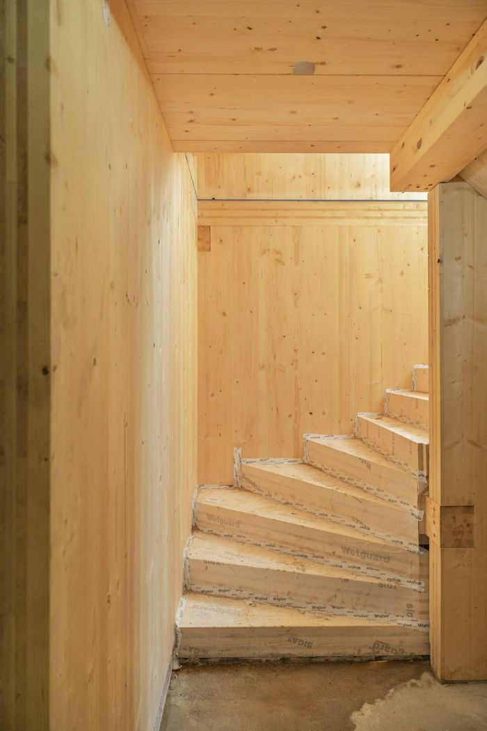 Houten trappenhuis met massief houten wanden in appartementengebouw in aanbouw