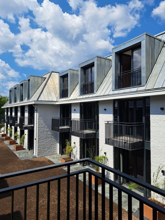 Uitbreiding en renovatie Van der Valk Hotel Wassenaar – binnenhof met hotelkamers, zinken dakkapellen en balkons aan witte gevels, gezien vanaf de galerij.