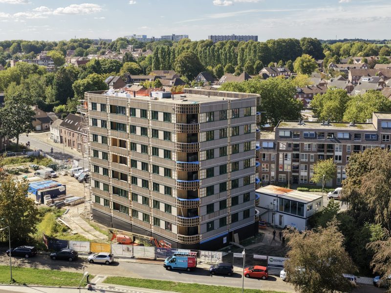 Appartementengebouw met balkons en omliggende woonwijk vanuit vogelperspectief