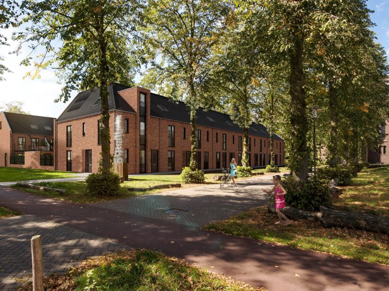 Kloostervelden Sterksel – impressie van rijwoningen in rood baksteen langs groene laan met hoge bomen, kerktoren op achtergrond