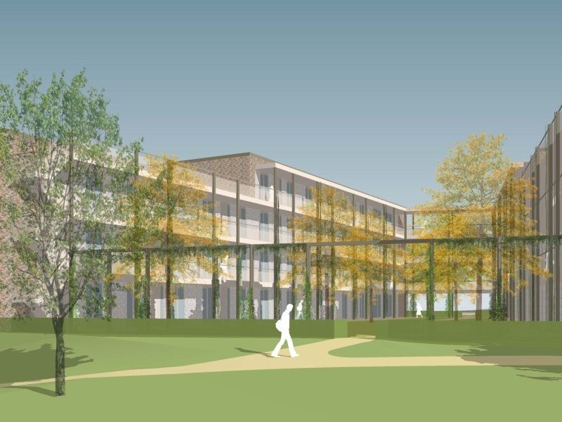 Gasthuishof Meerssen – impressie van groene binnentuin met pergola en bomen tussen bakstenen woongebouwen met galerijen