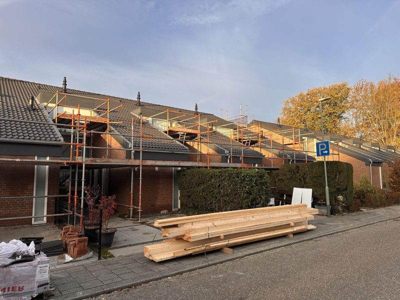 Verduurzaming van rijwoningen in Wijlre met steigers voor renovatie van gevels en dakisolatie.