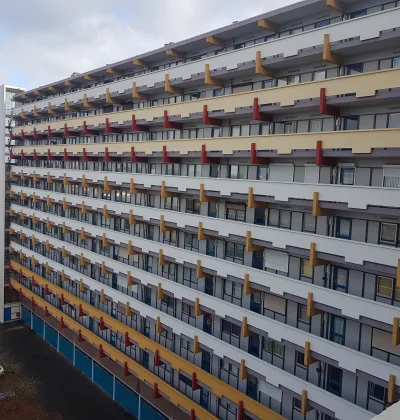 Appartementencomplex met lange galerijen en balkons met gele en rode gevelelementen