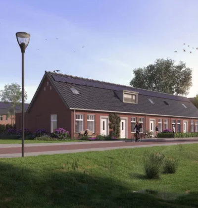 Rijwoningen met bakstenen gevels en dakramen langs fietspad en groenstrook